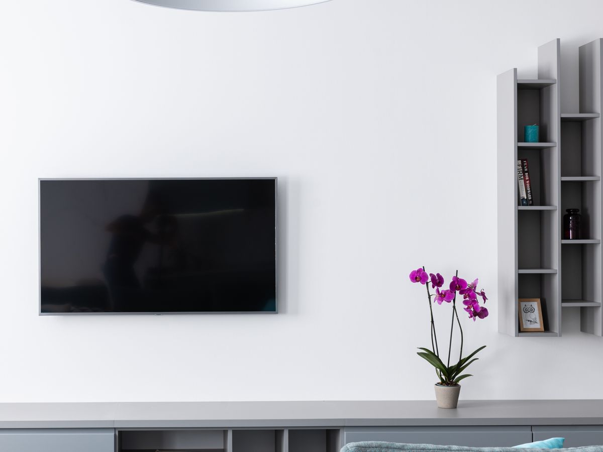 Wall-mounted TV on a clean white wall with no visible cables
