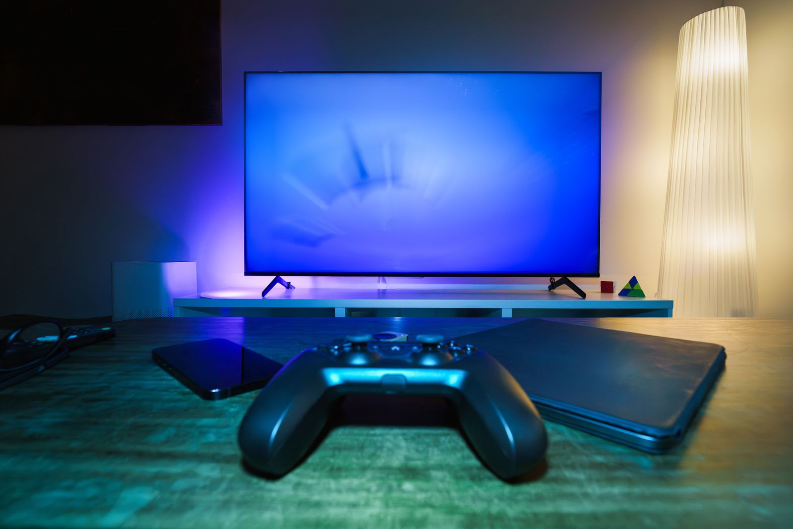 TV and game controller lit with a blue glow